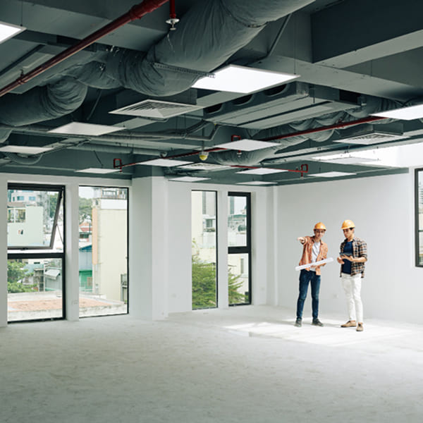 Vue intérieure d'un espace commercial modernisé avec deux entrepreneurs en construction inspectant les travaux