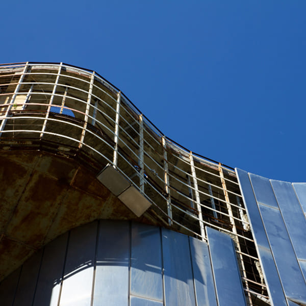 Bâtiment industriel en cours de rénovation avec revêtement de façade en cours d'installation