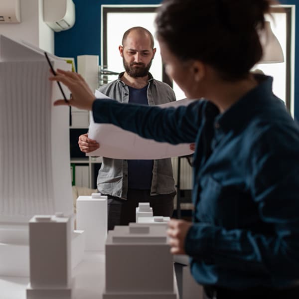 Architectes analysant une maquette urbaine pour planifier un aménagement commercial à Montréal