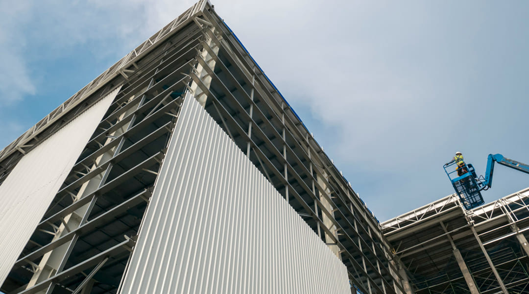 Rénovation de bâtiment industriel au Québec — ouvrier sur nacelle lors de travaux de façade