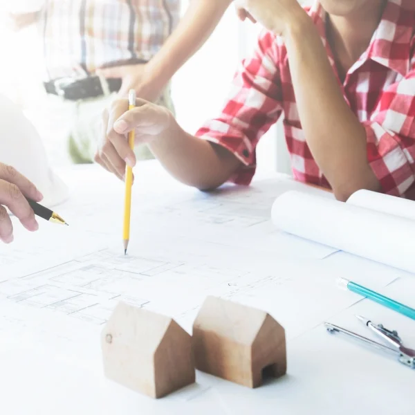 Un groupe de personnes collaborant sur un projet, échangeant des idées autour d'une table de travail.